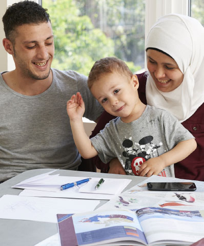 A Syrian Family consisting of a father, a mother wearing a hijab and a young boy in a consultation at Woodgreen.