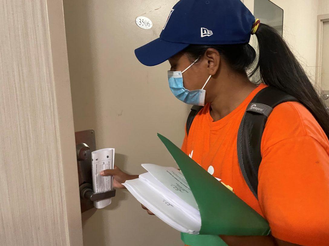 Volunteer Community Ambassador Farjana Yasmin goes door-to-door in a building in Crescent Town to get the word out about vaccines.