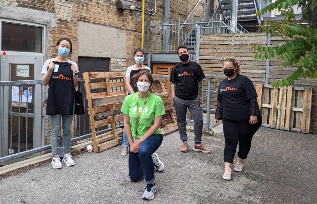 A group of WoodGreen corporate volunteers, socially distanced and wearing masks outside a building.